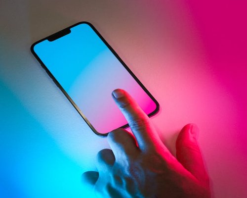 A hand lowering the brightness slider on a smartphone screen